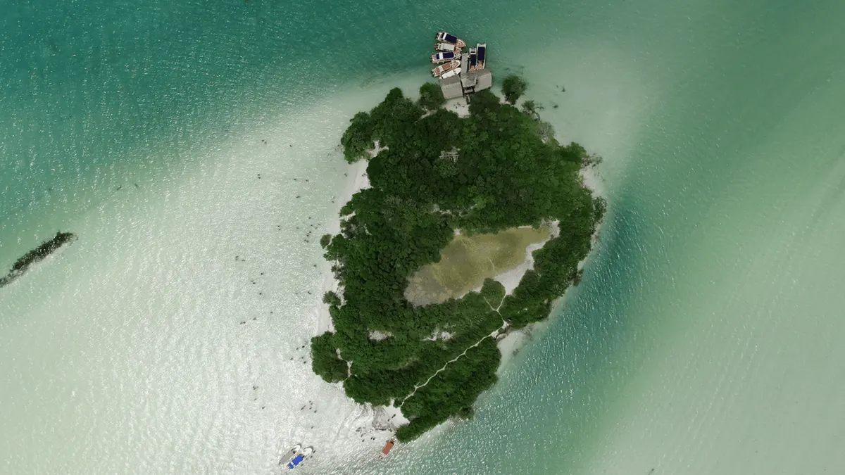 A boat on the shallow turquoise water around car-free Holbox island on a day trip from Playa del Carmen, Mexico
