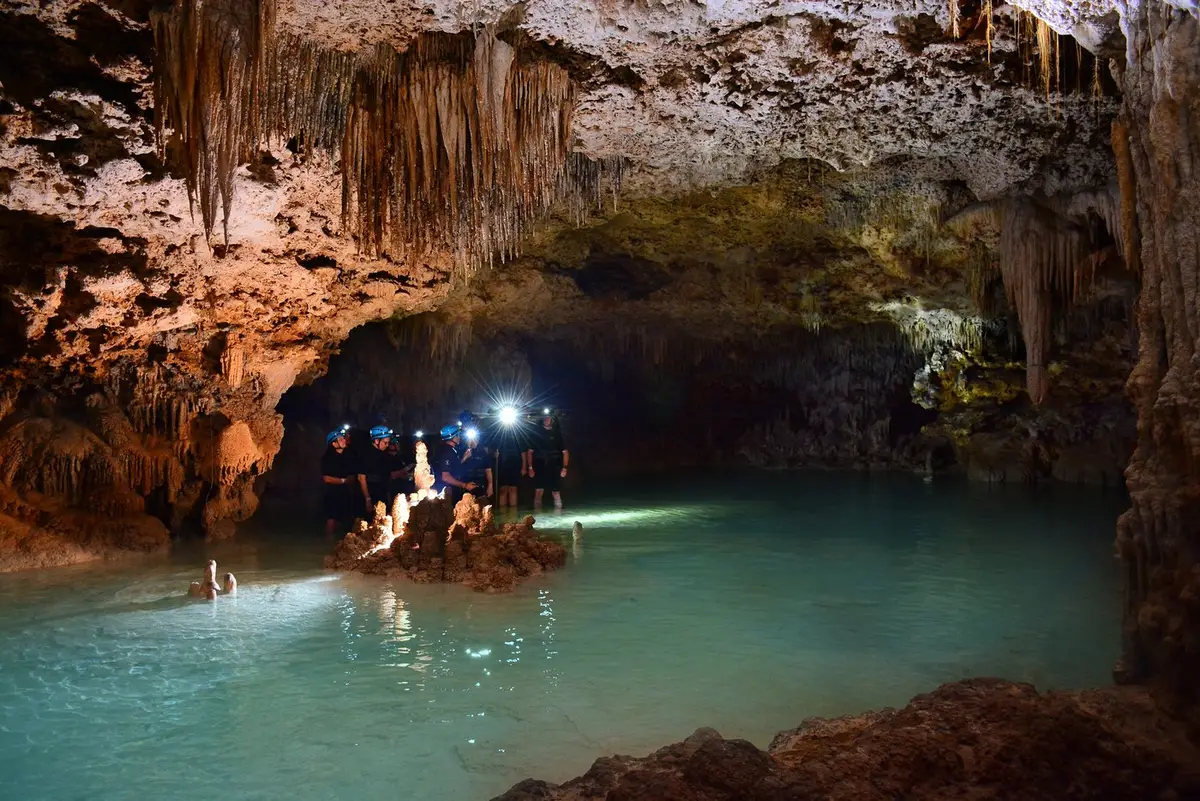 Stalactite and stalagmite formations reflected in still cave water at Río Secreto on a tour from Playa del Carmen, Mexico